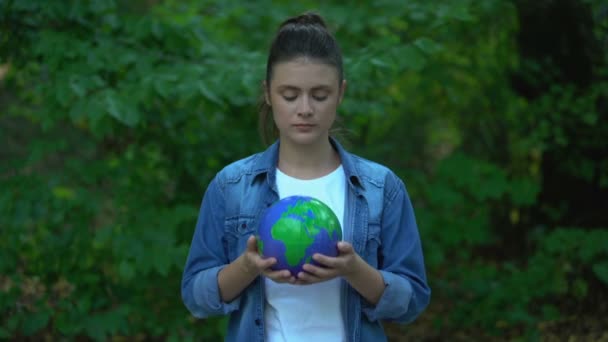 Joven hembra abrazando planeta plástico de pie en el bosque, protección del medio ambiente — Vídeo de stock