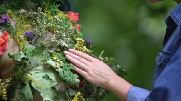 Mulher admirando folhas verdes e flores conectando com a mãe natureza na floresta — Vídeo de Stock