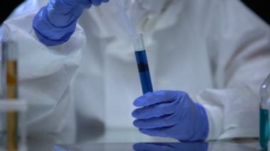 Zehirli laboratuvar bilim adamı mavi iyonize radyasyon sıvı tehlike örneğini inceliyor.