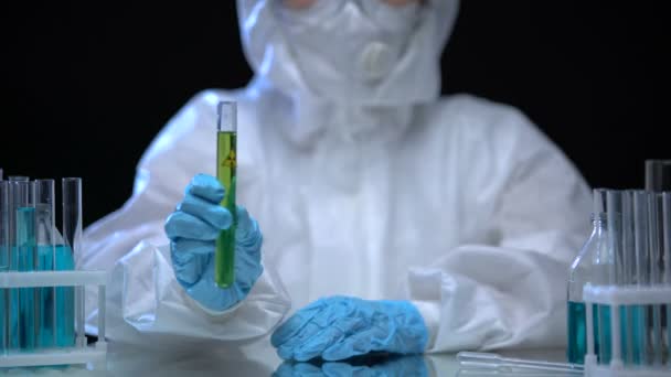 Giftig laboratoriumpersoneel dat reageerbuis met groene ioniserende stralingsvloeistof vasthoudt — Stockvideo