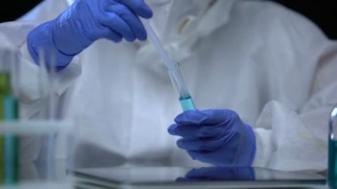 Zehirli laboratuvar asistanı kemirgen zehrini inceliyor, tüpte zehir işareti var.