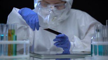 Kimyasal laboratuvar araştırmacısı test tüpünü naphtha ile inceliyor, yakıt kalitesi