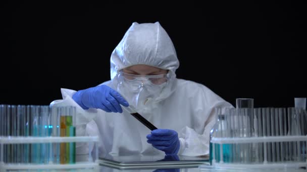 Работник лаборатории показывает образец токсичного грунта перед камерой, загрязнение — стоковое видео