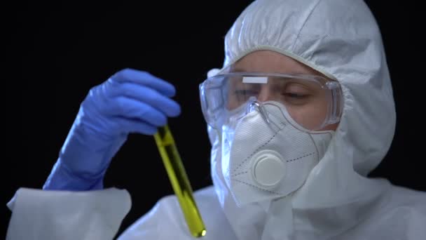 Trabalhador de laboratório de combustível ilegal segurando em mãos tubo de ensaio com aditivo inflamável — Vídeo de Stock