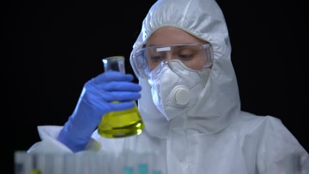 Woman laboratory assistant holding flask with flammable liquid, toxic igniter — Stock Video