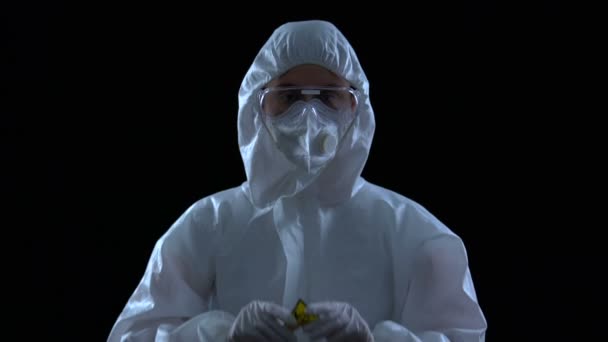 Travailleur de laboratoire en combinaison de protection portant le symbole de danger biologique, arme — Video