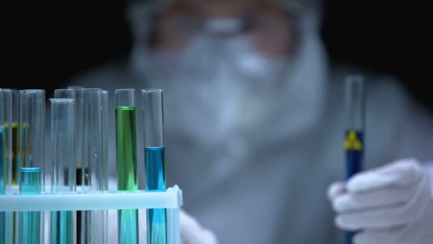 Trabalhador de laboratório adicionando líquido em tubo com sinal de perigo biológico, desenvolvimento de toxinas — Vídeo de Stock