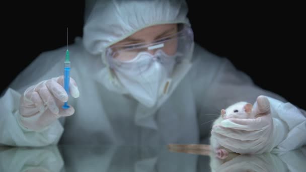 Investigador médico sosteniendo jeringa con sustancia azul y rata, prueba toxicológica — Vídeos de Stock