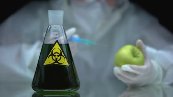Pesquisador injetando líquido de risco biológico na maçã, impacto da toxina no organismo vivo — Vídeo de Stock