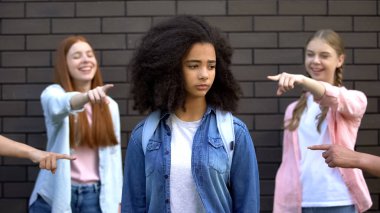 Kıvırcık afro-amerikan kız öğrenci, ırkçılık parmaklarını işaret gençlerin Zalim grup