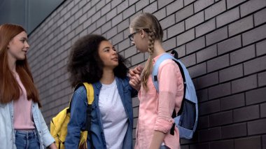 Gözlüklü mütevazı sınıf arkadaşına zorbalık eden akranlarla alay etmek, okulda fiziksel taciz