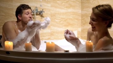 Neşeli çift girdap, romantizm su ve köpük ile oynarken eğleniyor