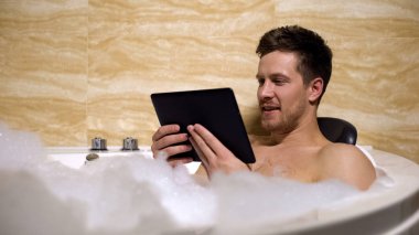 Yakışıklı adam banyo alarak ve tv programı izlerken zor iş günü sonra rahatlatıcı