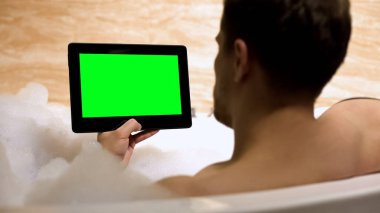 Evde küvette istirahat yeşil ekran tablet haber okuma Guy, rahatlayın