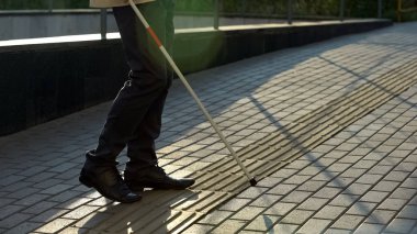 Kör erkek beyaz baston ile dokunsal kaldırım bulma, güvenli bir şekilde açık havada tek başına yürüme