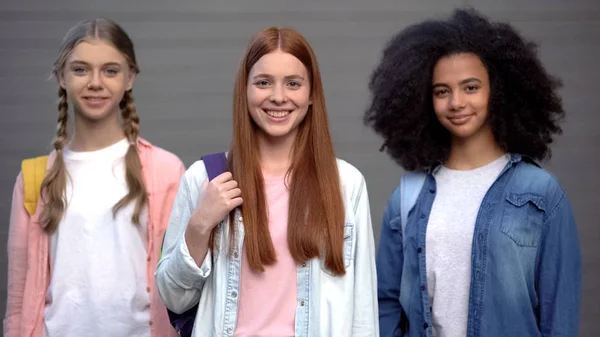 Adolescentes Femeninas Con Bolsas Escolares Sonriendo Cámara Programa Intercambio Estudiantes — Foto de Stock