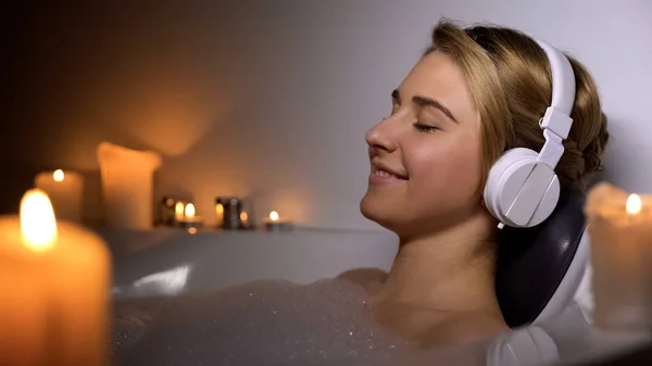 Chica Positiva Auriculares Acostado Baño Con Espuma Velas Escuchando Música — Foto de Stock