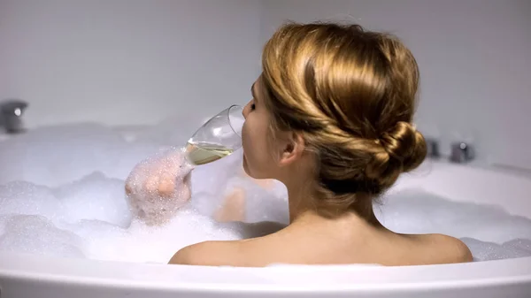 女人喝香槟在浴缸与泡沫泡沫 温泉冷 后视图 — 图库照片