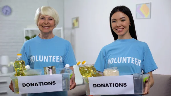 Sonriendo Voluntarios Mayores Jóvenes Sosteniendo Cajas Donación Alimentos Mirando Cámara — Foto de Stock