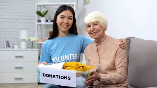 Activista Cariñosa Abrazando Pensionista Femenina Sosteniendo Caja Donaciones Apoyo Cuidado —  Fotos de Stock