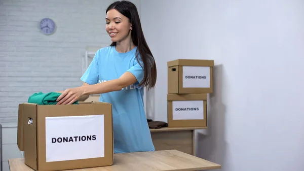 Female Volunteer Putting Clothes Donation Box Working Social Center — Stock Photo, Image
