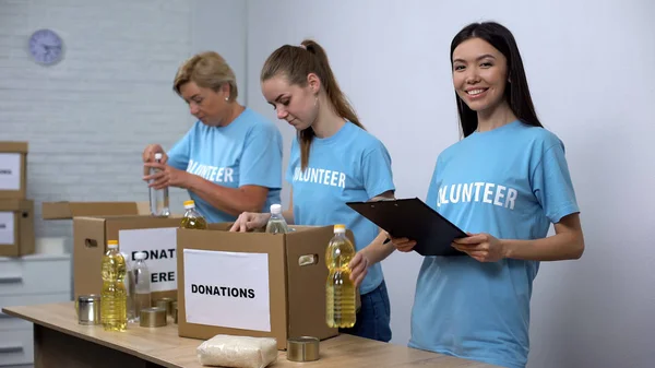 Trabajadores Centros Sociales Preparando Cajas Donación Alimentos Haciendo Notas Voluntariado — Foto de Stock