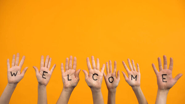 Welcome written palms on orange background, community togetherness, invitation