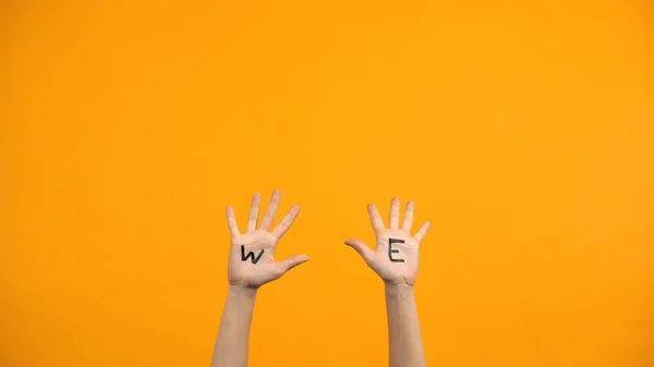 Kami Menulis Telapak Tangan Pada Latar Belakang Oranye Relawan Mengangkat — Stok Foto