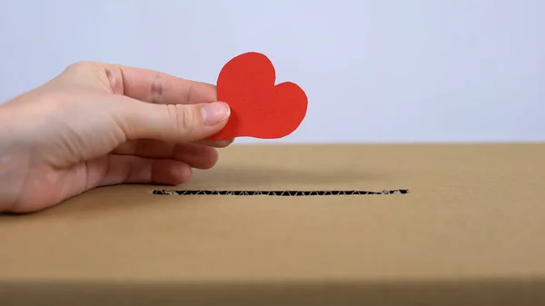 Female Hand Putting Red Heart Sign Cardboard Box Donation Center — Stock Photo, Image