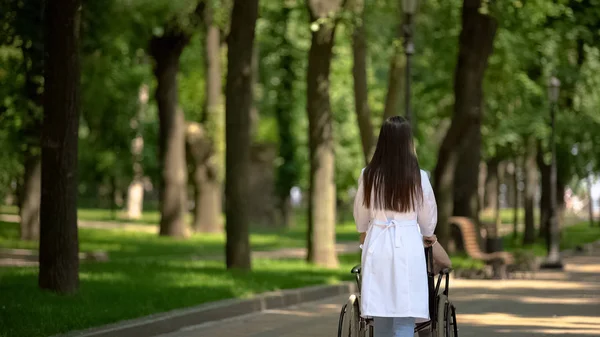 Ehrenamtliche Spaziergängerin Mit Behindertem Patienten Krankenhauspark Rückansicht — Stockfoto