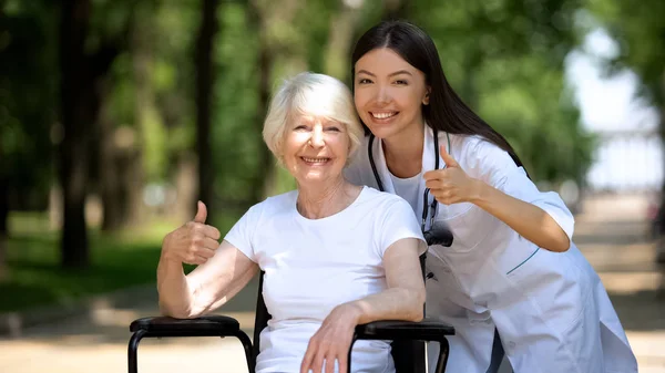 Infirmière Vieille Femme Handicapée Souriant Caméra Montrant Geste Pouce Levé — Photo