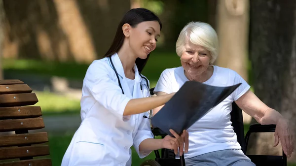 Усміхнена Жінка Лікар Показує Рентген Хребта Щасливій Літній Жінці Інвалідному — стокове фото