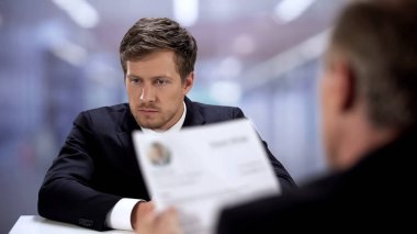 Şirket İnsan Kaynakları yöneticisi genç adam özgeçmiş, iş görüşmesi kavramı ile izliyor