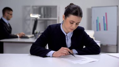 Female office manager working with documents, boring paper work, overworking