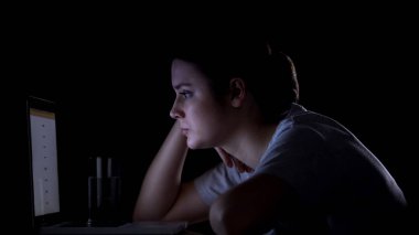 Kız freelancer gece geç saatlerde dizüstü bilgisayar üzerinde çalışan, yorgun ve uykulu görünümlü