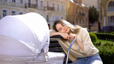 Tired young female sleeping on newborn carriage, lack of energy, exhaustion clipart