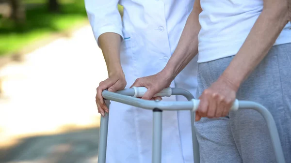 Kvinnlig Sjuksköterska Stödja Funktionshindrade Gammal Dam Med Gång Ram Utomhus — Stockfoto