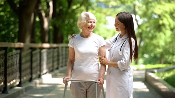 Terapeuta Feliz Señora Mayor Con Marco Para Caminar Mirándose Parque —  Fotos de Stock