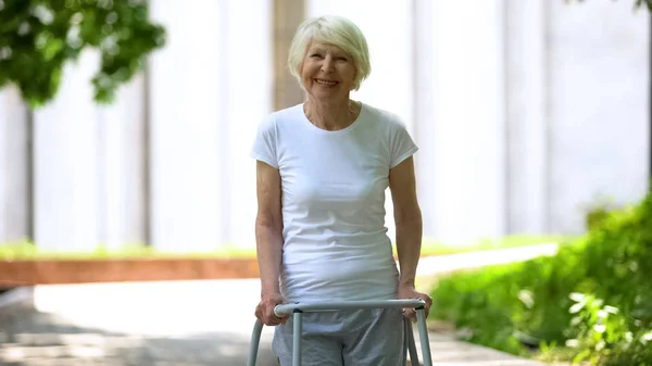 Cheerful Senior Woman Walking Frame Looking Camera Outdoors Rehab — Stock Photo, Image