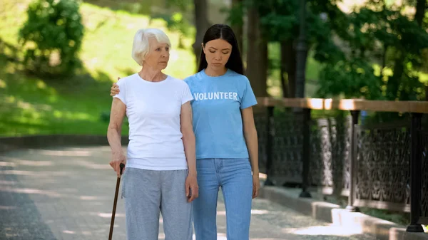 庭で歩く棒と女性ボランティアとうつ病の成熟した女性 リハビリ — ストック写真