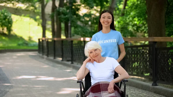 Uśmiechnięta Kobieta Wolontariuszy Niepełnosprawnych Starszy Kobieta Szuka Aparatu Miłości — Zdjęcie stockowe