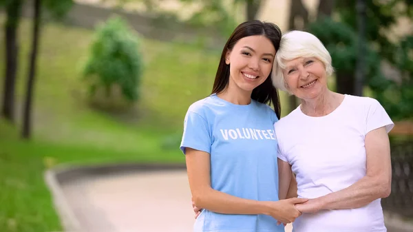 Γυναίκα Εθελόντρια Και Ευτυχισμένη Ηλικιωμένη Κυρία Κρατώντας Χέρια Χαμογελαστά Κάμερα — Φωτογραφία Αρχείου