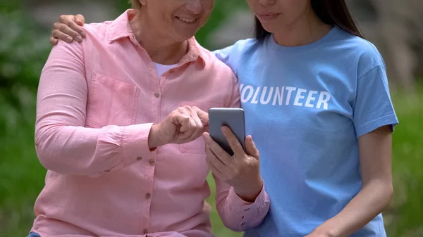 Mujer Madura Joven Voluntario Buscando Fotos Teléfonos Inteligentes Juntos Asistencia — Foto de Stock