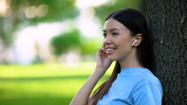 Donna Sorridente Con Auricolari Wireless Che Ascolta Musica Seduta Nel — Foto Stock