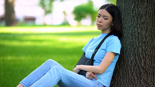 Sad Lady Injured Arm Supporting Sling Sitting Tree Park Medicine — Stock Photo, Image