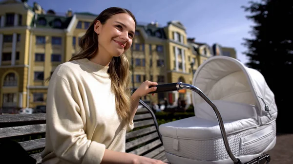 Leende Ung Mamma Med Baby Vagn Sitter Parkbänk Solig Dag — Stockfoto