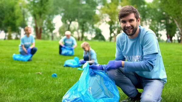 Ευτυχισμένος Άντρας Εθελοντής Που Βάζει Σκουπίδια Σακούλα Σκουπιδιών Και Χαμογελά — Φωτογραφία Αρχείου