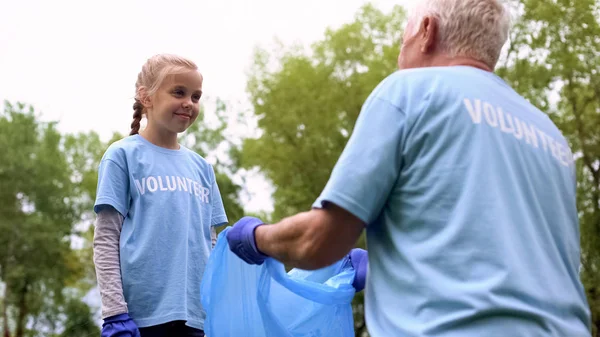 Niña Poniendo Basura Una Bolsa Plástico Ayudando Abuelo Juntos — Foto de Stock