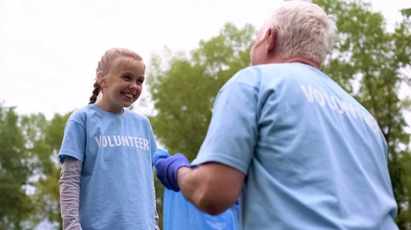 Niña Sonriente Mirando Abuelo Sosteniendo Bolsa Basura Eco Voluntarios — Foto de Stock