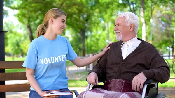 Vrouwelijke Vrijwilliger Houden Boek Tijd Doorbrengen Met Gehandicapte Ouderen Man — Stockfoto